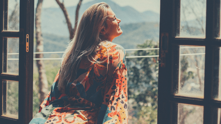 Woman smiling looking out an open window